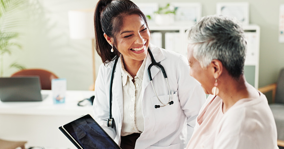 Mature woman, doctor and tablet for healthcare, support or conversation with checkup appointment in office. Female person, medical professional and diagnosis talk for senior patient at clinic