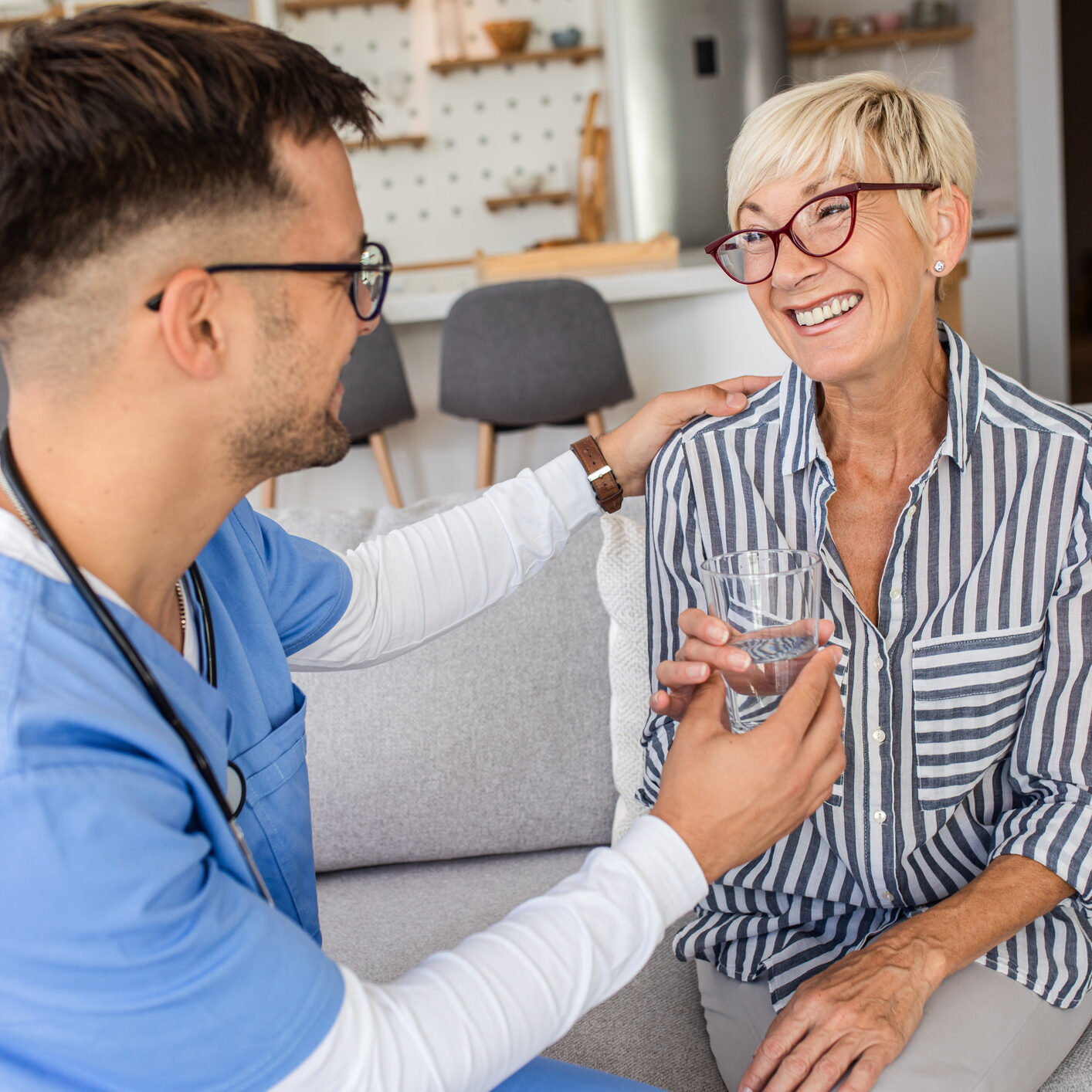 Male nurse talking to seniors patients while being in a home visit.