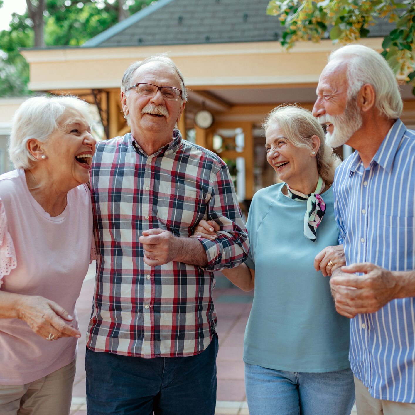 Cheerful Senior Friends Enjoying Afternoon Together. Group of Four Mature People Outside Laughing. Happy Senior Man and Old Woman Enjoying Together